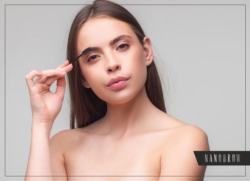 Kobietę przeczesująca brwi i patrząca w kamerę